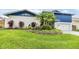 Charming two-story home with a vibrant blue accent and lush landscaping at 15609 Gardenside Ln, Tampa, FL 33624