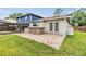 View of the home's backyard, outdoor stone bar, and access to the screened-in pool at 15609 Gardenside Ln, Tampa, FL 33624