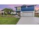 Charming two-story home with vibrant blue siding, white accents, and a well-manicured lawn at 15609 Gardenside Ln, Tampa, FL 33624