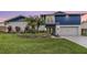 Charming two-story home with a vibrant blue accent and lush landscaping at 15609 Gardenside Ln, Tampa, FL 33624
