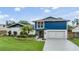Charming two-story home with a vibrant blue accent and lush landscaping at 15609 Gardenside Ln, Tampa, FL 33624