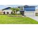 Charming two-story home with a vibrant blue accent and lush landscaping at 15609 Gardenside Ln, Tampa, FL 33624
