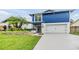 Charming two-story home with a vibrant blue accent and lush landscaping at 15609 Gardenside Ln, Tampa, FL 33624