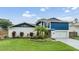Charming two-story home with a vibrant blue accent and lush landscaping at 15609 Gardenside Ln, Tampa, FL 33624