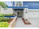 Charming home featuring a covered entryway, lush landscaping, and a bright, welcoming facade at 15609 Gardenside Ln, Tampa, FL 33624