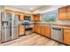 Updated kitchen featuring stainless steel appliances and wooden cabinetry, providing ample storage at 15609 Gardenside Ln, Tampa, FL 33624