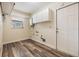 Efficient laundry room with ample storage cabinets and modern flooring at 15609 Gardenside Ln, Tampa, FL 33624
