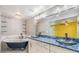 Stylish main bathroom with a clawfoot tub, double vanity, and custom glass shelving at 15609 Gardenside Ln, Tampa, FL 33624