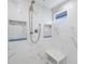 Modern shower featuring decorative tile, built-in shelving, and a sleek design at 15609 Gardenside Ln, Tampa, FL 33624