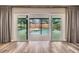 View of the screened-in pool and backyard through the expansive sliding glass doors at 15609 Gardenside Ln, Tampa, FL 33624