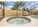 Close-up of the bubbly spa area with tiled edges within the screened-in pool enclosure at 15609 Gardenside Ln, Tampa, FL 33624