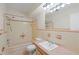 The bathroom features a bathtub-shower combo, a toilet, a sink and an expansive mirror at 1579 Palmetto St, Clearwater, FL 33755