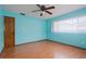 Bright bedroom with wood-look floors, a ceiling fan, a window for natural light, and a closet door at 1579 Palmetto St, Clearwater, FL 33755