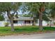Charming single-story home with blue accents surrounded by mature trees and a well-maintained lawn at 1579 Palmetto St, Clearwater, FL 33755