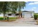 Charming single-story home with a well-maintained lawn, blue accents and a single car garage at 1579 Palmetto St, Clearwater, FL 33755
