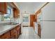Functional kitchen with wood cabinets, tile countertops, and white appliances at 1579 Palmetto St, Clearwater, FL 33755