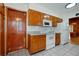 Efficient kitchen featuring wood cabinets, white appliances, and tile floors at 1579 Palmetto St, Clearwater, FL 33755