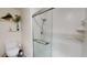 All-white bathroom featuring a glass-enclosed shower, white tile and modern toilet on a patterned tile floor at 1712 Lake Cypress Dr # 1604, Safety Harbor, FL 34695