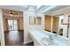 Bright bathroom featuring a white vanity, mosaic tile, and large mirror; bedroom and balcony are reflected at 1712 Lake Cypress Dr # 1604, Safety Harbor, FL 34695