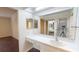 Bathroom with tile counters, a large mirror and a peek into bedroom at 1712 Lake Cypress Dr # 1604, Safety Harbor, FL 34695
