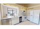 Kitchen with white cabinets, tiled floor, and a window looking out onto the yard at 1712 Lake Cypress Dr # 1604, Safety Harbor, FL 34695
