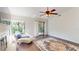 Bright living room boasts hardwood floors, a ceiling fan, and sliding glass doors to a private balcony at 1712 Lake Cypress Dr # 1604, Safety Harbor, FL 34695
