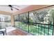 Outdoor patio showcasing lush green lawn viewed from behind black metal railings, with a ceiling fan at 1712 Lake Cypress Dr # 1604, Safety Harbor, FL 34695