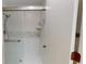 White tile shower with sliding glass doors and multiple shelves at 1712 Lake Cypress Dr # 1604, Safety Harbor, FL 34695