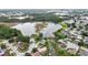 Aerial view of a neighborhood featuring mature trees, lush landscaping, and a pretty pond at 1717 Osprey Ln, Lutz, FL 33549