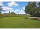 Large, grassy backyard with mature trees and plenty of open space at 1717 Osprey Ln, Lutz, FL 33549