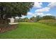 Expansive, grassy backyard with lush greenery and some trees creating a private space at 1717 Osprey Ln, Lutz, FL 33549
