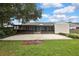 View of the house's backyard featuring a screened in porch and a concrete patio at 1717 Osprey Ln, Lutz, FL 33549