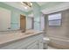 This bathroom features a single sink vanity, tub, and tile walls at 1717 Osprey Ln, Lutz, FL 33549
