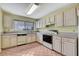 Functional kitchen featuring white appliances, tile flooring, and ample cabinet space at 1717 Osprey Ln, Lutz, FL 33549