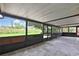 Enclosed lanai providing an outdoor living space with views of the green backyard at 1717 Osprey Ln, Lutz, FL 33549