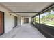 Wide view of the screened-in lanai connecting to the house with sliding doors and a serene outdoor view at 1717 Osprey Ln, Lutz, FL 33549