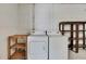 Functional laundry area equipped with a washer, dryer, and wooden shelving units at 1717 Osprey Ln, Lutz, FL 33549