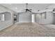 Open concept living room with neutral carpet and ceiling fan at 1717 Osprey Ln, Lutz, FL 33549