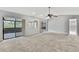 Spacious living room with ceiling fan, sliding doors to the lanai, neutral paint and wall mirror at 1717 Osprey Ln, Lutz, FL 33549