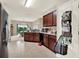 Functional kitchen featuring dark wood cabinets, tile flooring and an adjacent dining area at 1737 Bonita Bluff Ct, Ruskin, FL 33570