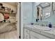 Bathroom with tile counter, oval mirror, and a peek into a walk-in closet at 17706 Morninghigh Dr, Lutz, FL 33549