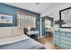 Relaxing bedroom featuring blue accent wall, a dresser, and a sliding closet mirror at 17706 Morninghigh Dr, Lutz, FL 33549