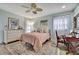 Airy bedroom features light blue walls, a dresser, a ceiling fan, and natural light at 17706 Morninghigh Dr, Lutz, FL 33549