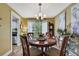 Cozy dining room features a round wooden table, chandelier lighting, and decor pieces at 17706 Morninghigh Dr, Lutz, FL 33549
