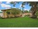 Well-manicured lawn and landscaped yard with mature trees surrounding the home's exterior at 17706 Morninghigh Dr, Lutz, FL 33549