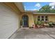 Inviting home exterior featuring a garage, stucco walls, and garden, creating a welcoming entrance at 17706 Morninghigh Dr, Lutz, FL 33549
