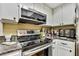 Modern kitchen with stainless steel appliances, white cabinets, and granite countertops at 17706 Morninghigh Dr, Lutz, FL 33549