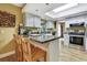 Eat-in kitchen features a breakfast bar, white cabinets, stainless appliances, and a skylight at 17706 Morninghigh Dr, Lutz, FL 33549