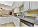 Kitchen features white cabinets, granite countertops, stainless steel appliances, and a view at 17706 Morninghigh Dr, Lutz, FL 33549