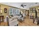 Bright living room with hardwood floors, a ceiling fan, and comfortable seating creating an inviting space at 17706 Morninghigh Dr, Lutz, FL 33549